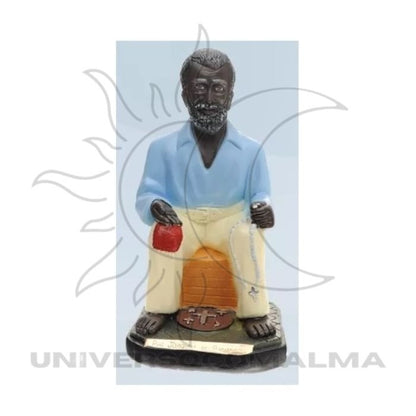 Estátua de Preto Velho sentado com camisa azul e calças claras